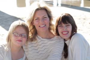 Melissa Yeager sits on the beach with her two daughters.