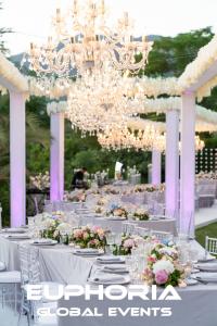 Here is the image of luxury curved wedding tables in Marbella, elegantly decorated with chandeliers and hanging wisteria flowers, capturing a sophisticated and romantic atmosphere.