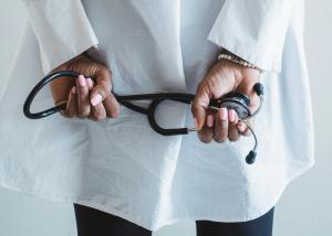 Doctor. Doctor holding stethoscope in a thoughtful manner.