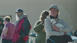 A woman holding her dog in line at a Feeding Pets of the Homeless sponsored animal wellness clinic in Reno, Nev.