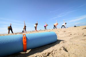 Packbands securing rolled yoga mat on the beach