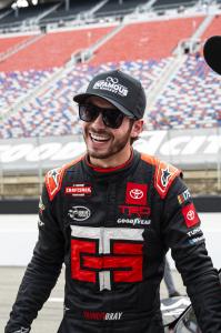 Tanner Gray flashes a smile in pit road. Infamous Whiskey sponsors Tanner Gray, driver of the #15 Toyota Tundra for TRICON Garage