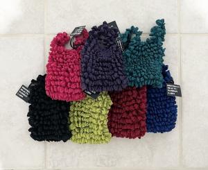 A collection of 7 small tote like bags in different colors. From left to right: Pink, Purple, Cyan, Black, Green, Red, Blue.