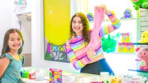 Ameerah stretching slime at the DIY Slime bar with a subscriber from her youtube channel