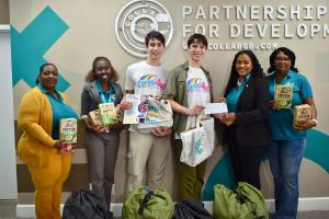 16-year-old twin brothers Jett and Luke Justin present Cereal4all breakfast food and donation check to Chevonia McBride from Ministry for Grand Bahama
