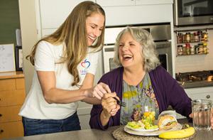 1Heart Caregiver helping senior with meal.