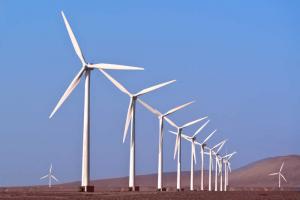 Several wind turbines tower above the hills. The rotating blades are blown by the wind, turning the generator set inside the generator, which converts wind energy into electricity.