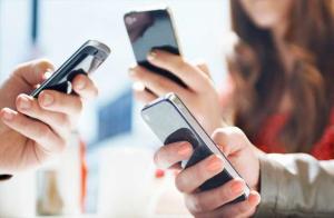 Three millennials holding cell phones, sending digital tips.