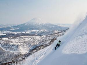 Snowboarder in Niseko Hanazono with Mount Youtei backdrop