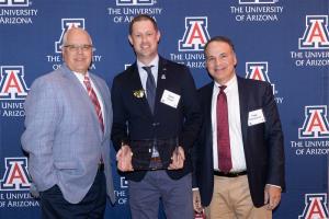 Dr. Goettl holding the award presented at the UArizona Alumni Foundation awards ceremony.