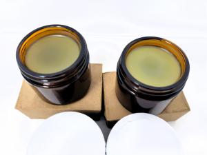 two open jars of cbd salve, showing the contents of the new jar