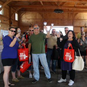 Group of people arriving at the Hudson Valley Wine Fest raising their glasses in a "cheers"