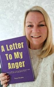 Author Tanya Heasley, smiling, holds her book 'A Letter to My Anger', its purple cover complementing her joyful expression, a testament to the book's life-changing message.