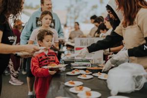 A child receiving pumpkin pie at 2023 Eat & Be Well