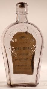 Frank Abadie pint-size, knife edge coffin Nevada whiskey bottle with the original paper nearly intact, clear in color, circa 1884-1886, one of the top Nevada whiskeys (est. $2,400-$4,000).