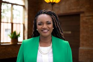 Fentrice Driskell a partner with Swope, Rodante P.A. headshot in office lobby wearing green jacket