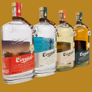 Four bottles of Tequila Corrido, each tied at the neck with a guitar pick on a brown leather cord.