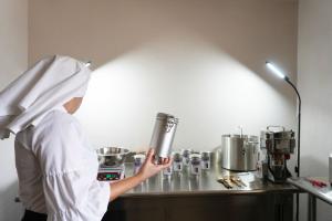 Sister Becky packaging the mushroom coffee in the lab, holding a tin that is complete