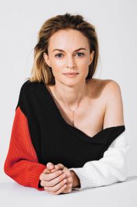 Heather Graham Official Portrait.  She is wearing a red, black and white outfit.