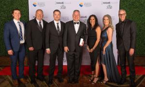 Camelot Homes team accepts 2024 MAME Builder of the Year award on stage