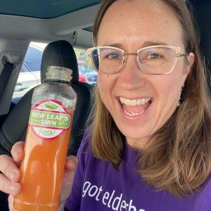 Carmel Berry Co. Founder, Katie Reneker, shown holding the new Carmel Berry Co. Elderberry boost in a juice bottle now featured at juice bars at New Leaf and Lazy Acres.