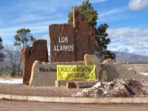 Los Alamos lab sign with no nukes banner
