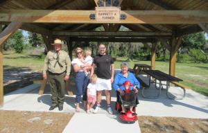 Representatives from the Florida Park Service and Florida State Parks Foundation join Garrett A. Turner to celebrate a new, accessible pavilion at Lake Manatee State Park in Bradenton.