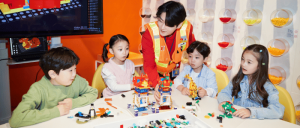A LEGOLAND Korea Resort staff assisting four children in doing their Lego activity.
