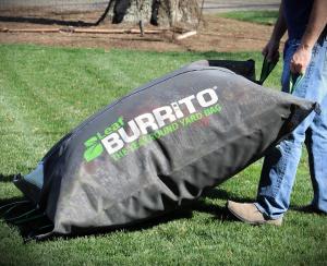 Leaf Burrito® The Year Round Yard Bag - zipped up and being dragged across the lawn by a homeowner.