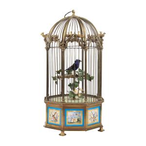 Circa 1885 French Bontems caged singing bird automaton in a bronze cage, 18 ½ inches tall, with applied scenic Sevres plaques surrounding the base panels (CA$10,030).