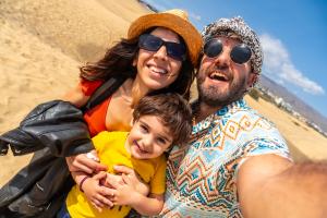 Family of three doing a selfie in sunny sand dunes