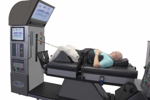 DRX9000 Lumbar & Cervical Spinal Decompression Machine with a geriatric patient being treated.  DRX9000 Harnesses are attached to the patient, belt from tower is connected to patient during treatment.