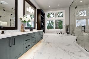 A beautiful renovated bathroom with seafoam green colored cabinetry