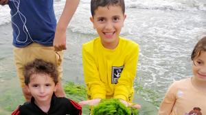 Four children, Mohammed, Mona, Abdallah, and Rasha, are playing on a beach in Gaza.