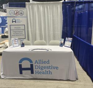 White table and backdrop with Allied Digestive Health signage.
