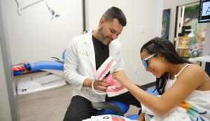 Dr. Jairo Montoya educates young patient about her oral health.