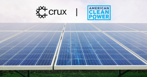 This is a color photograph of solar panels with the Crux and American Clean Power logos at the top of the image