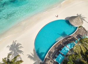 Nova Maldives' Solis Pool with woman walking on beach