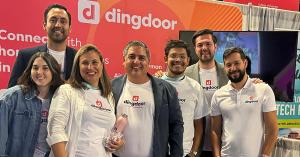 Image of the vibrant Dingdoor team actively participating in a local community event, showcasing unity and enthusiasm as they engage with attendees, all smiles and wearing Dingdoor-branded T-shirts.