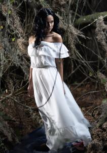 Beautiful woman in white dress along swamp.