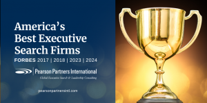 Pearson Partners International Named by Forbes as One of America’s Best Executive Search Firms - with an image of a gold trophy on a blue background with spotlights