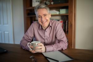 Mission Coaching executive coach Paul Barnard sits with a cup of coffee ready to work with business executives all over the world