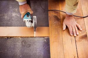 An unrecognized hardwood refinisher skillfully grinding wooden planks with precision and expertise