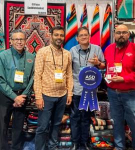 El Paso Saddleblanket poses for the camera as they receive the award for Best New Exhibitor at the ASD Market Week.
