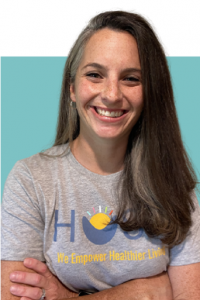 Image of a woman wearing a corporate t-shirt featuring the HUSK logo