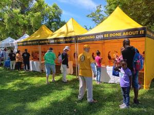 This is a photo of people coming to the yellow tent of the Scientology Volunteer Ministers
