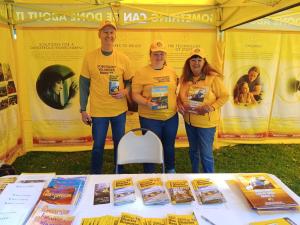 This is a photo of three Yellow Shirted Volunteers offering free information to help people