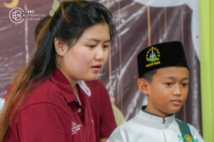 EBC employee with a student from Nurul Ibad Child Welfare Institution, both smiling.