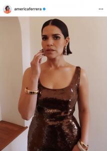 Actress America Ferrera is posing for a picture wearing a sleeveless elegant dress, her hair is styled in a bob with flipped ends