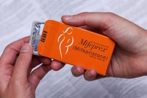 Mifepristone pill, often used with Misoprostol for medical abortion. The stripe of Mifeprex or Mifepristone, which is yellow pill, marked for identification, is held in the patient's hand.
